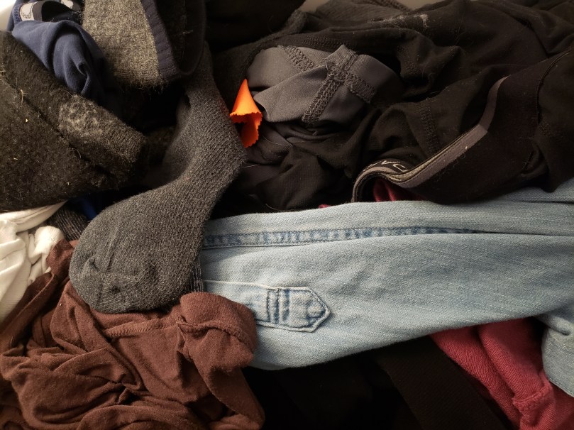 View from above of a basket of clean laundry that wants folding.